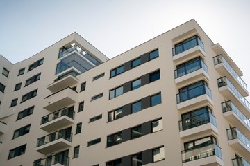 Fototapeta premium Exterior of new apartment buildings on a blue cloudy sky background. No people. Real estate business concept.
