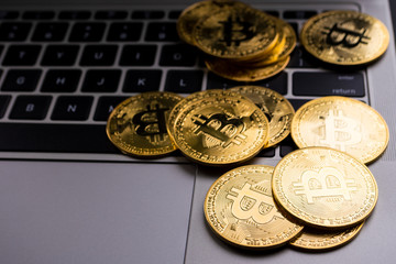 Golden coins with bitcoin symbol on computer keyboard.