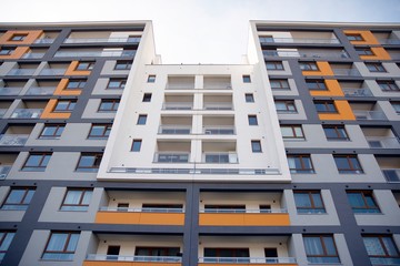 Exterior of new apartment buildings on a blue cloudy sky background. No people. Real estate business concept.