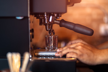 Barista making fresh coffee with coffee machine in cafe