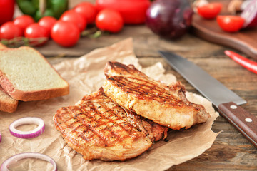 Cooked pork steaks and bread on table