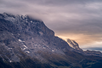 Panoramic view of tall rocky mountain peaks shrouded in cloud in the alpine region of Grindelwald, Switzerland.