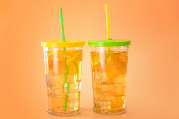 Glasses of tasty cold ice tea on color background