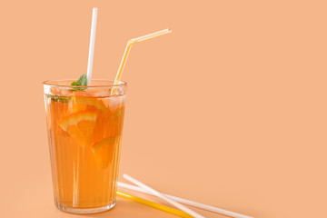 Glass of tasty cold ice tea on color background
