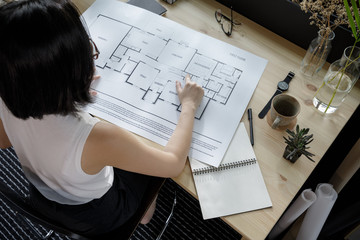 Young businesswoman architecture freelance looking at the blueprint working from home lifestyle in...