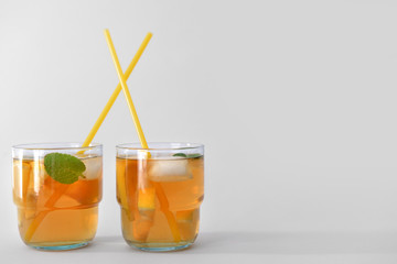 Glasses of tasty cold ice tea on grey background