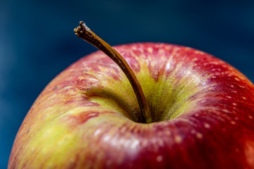 Red apple close-up from above. Blue background