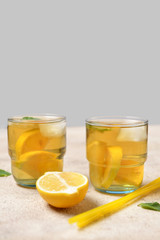 Glasses of tasty cold ice tea on grey background