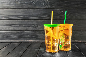 Glasses of tasty cold ice tea on dark wooden background