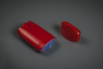 Empty red deodorant stick with open top on a gray background. Visible empty deodorant stick with...