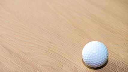 white golf ball on a wooden surface
