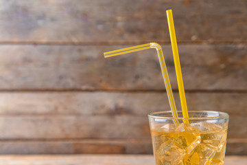 Glass of tasty cold ice tea on wooden background