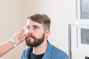 Medicine, health, ophthalmology concept - Ophthalmologist examines patient's eyes.