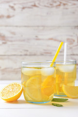 Glasses of tasty cold ice tea on white wooden background