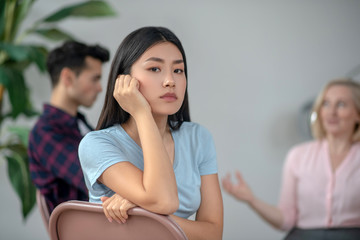 Long-haired asian girl siting and looking aside