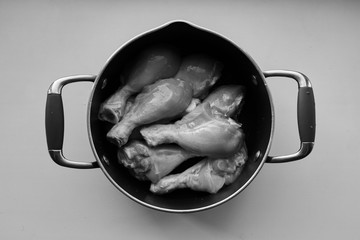 Fresh chicken legs in a pan one second before cooking.