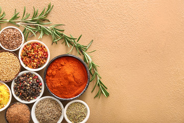 Different spices in bowls on color background