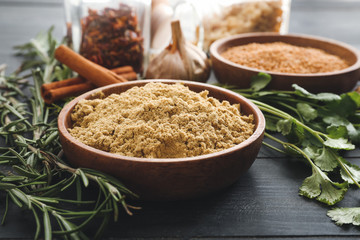 Plate with spices on dark wooden background