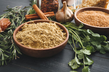 Different spices on dark wooden background