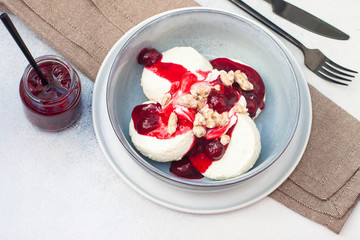 Cottage cheese pancakes with cherry sauce and nuts in grey bowl. Close up. Healthy breakfast concept.