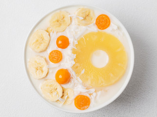 Healthy bowl of a cocktail of pineapple, coconut, bananas and Physalis. 