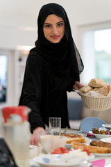 Muslim girls preparing table for family meal