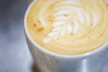 Cup of coffee with milk. Lattee art. Blurred background. Hot seasonal drink.