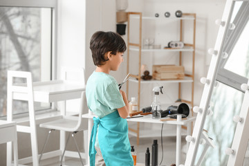 Cute little hairdresser in beauty salon