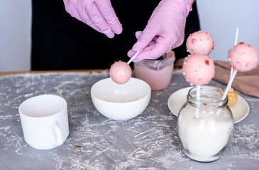 The pastry chef makes dessert on a stick. Cake pops. Chocolate cream for dessert, creation process.
