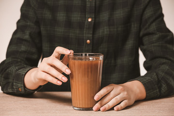 Woman with glass of cold coffee on table