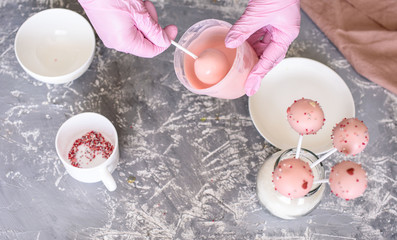 The pastry chef makes dessert on a stick. Cake pops. Chocolate cream for dessert, creation process.