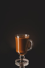 Glass cup with iced coffee on dark background