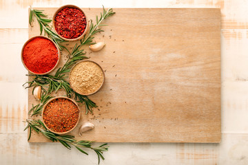 Different spices with board on wooden background