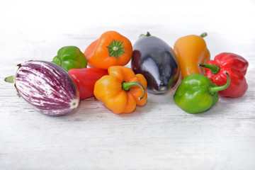 collection of colorful vegetables as peppers and eggplants on a white table