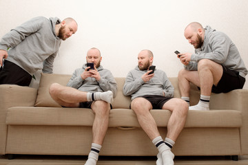Collage of male cloned sits on the couch in various poses and uses a smartphone. Composite of multiple Human clones doing different activities at home during lockdown due to COVID pandemic