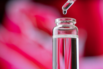 Blend of essential oils. Making some aroma liquids. Drops falling from pippet to little glass...