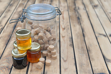 little jar piled of fresh honey and sugar cubes on a wooden table
