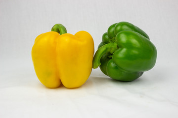 Three bell peppers, red, yellow and an orange one with white background