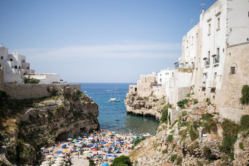 Fototapeta na wymiar Beautiful beach with people in Polignano a Mare in the southern part of Italy crystal clear azure water