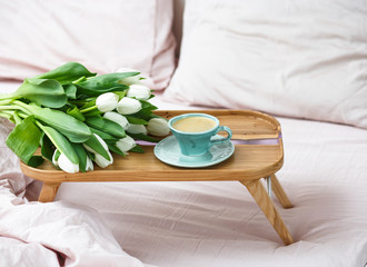 Romantic morning.A coffee table in a pink bed, a Cup of coffee and flowers on the table....