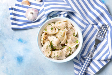 Bowl with tasty dumplings on color background