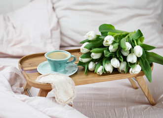 Romantic morning.A coffee table in a pink bed, a Cup of coffee and flowers on the table. Valentine's day