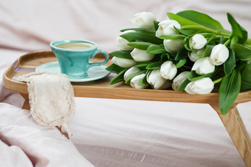 Romantic morning.A coffee table in a pink bed, a Cup of coffee and flowers on the table. Valentine's day