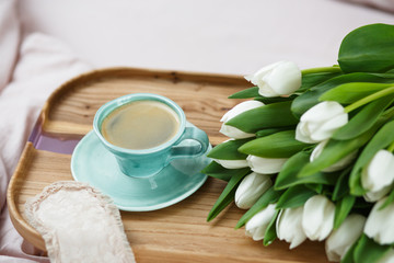 Romantic morning.A coffee table in a pink bed, a Cup of coffee and flowers on the table. Valentine's day