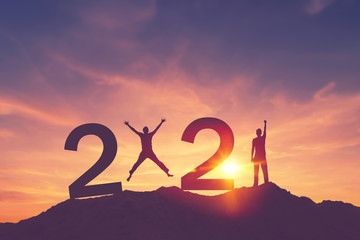 Man raise hand up and man jumping on sunset sky at top of mountain and number like 2021 abstract background. Happy new year and holiday celebration concept.