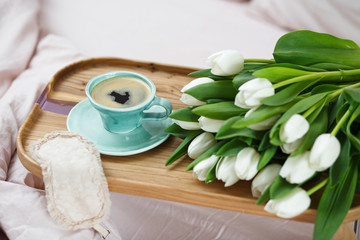 Romantic morning.A coffee table in a pink bed, a Cup of coffee and flowers on the table. Valentine's day