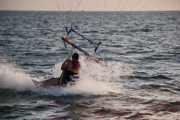 Fototapeta premium A young man and a girl are flying on a double parachute behind a boat over the sea.