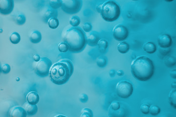 Many round bubbles of the shower gel on the blue background.