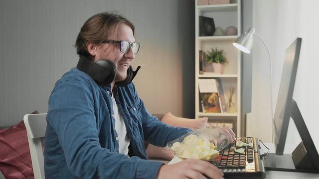 Side view of Young man playing video game at home feeling happy after winner and showing indecent gesture