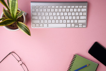 Blank notebook with pen are on top of white office desk table with computer tools and others